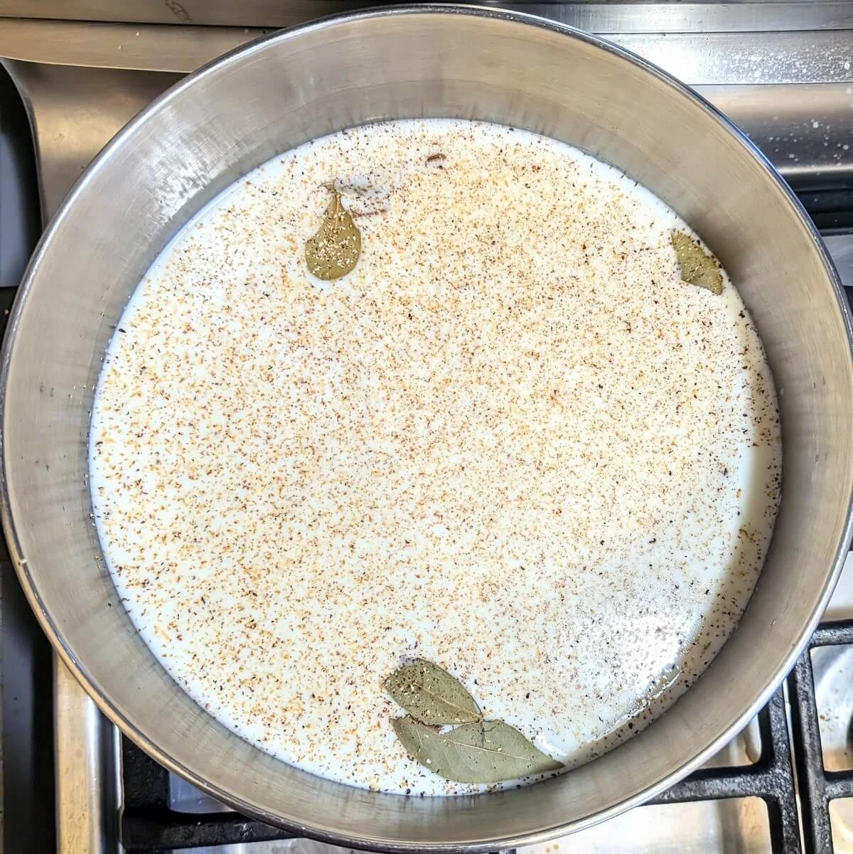Milk steeping with nutmeg, garlic, and bay leaves for an easy bechamel sauce recipe