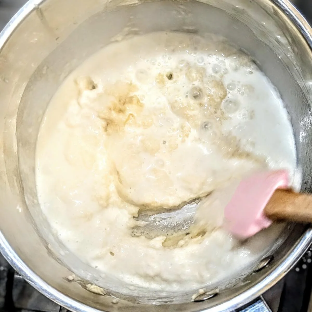 Steeped milk being whisked into roux to make 1 litre bechamel sauce recipe from scratch