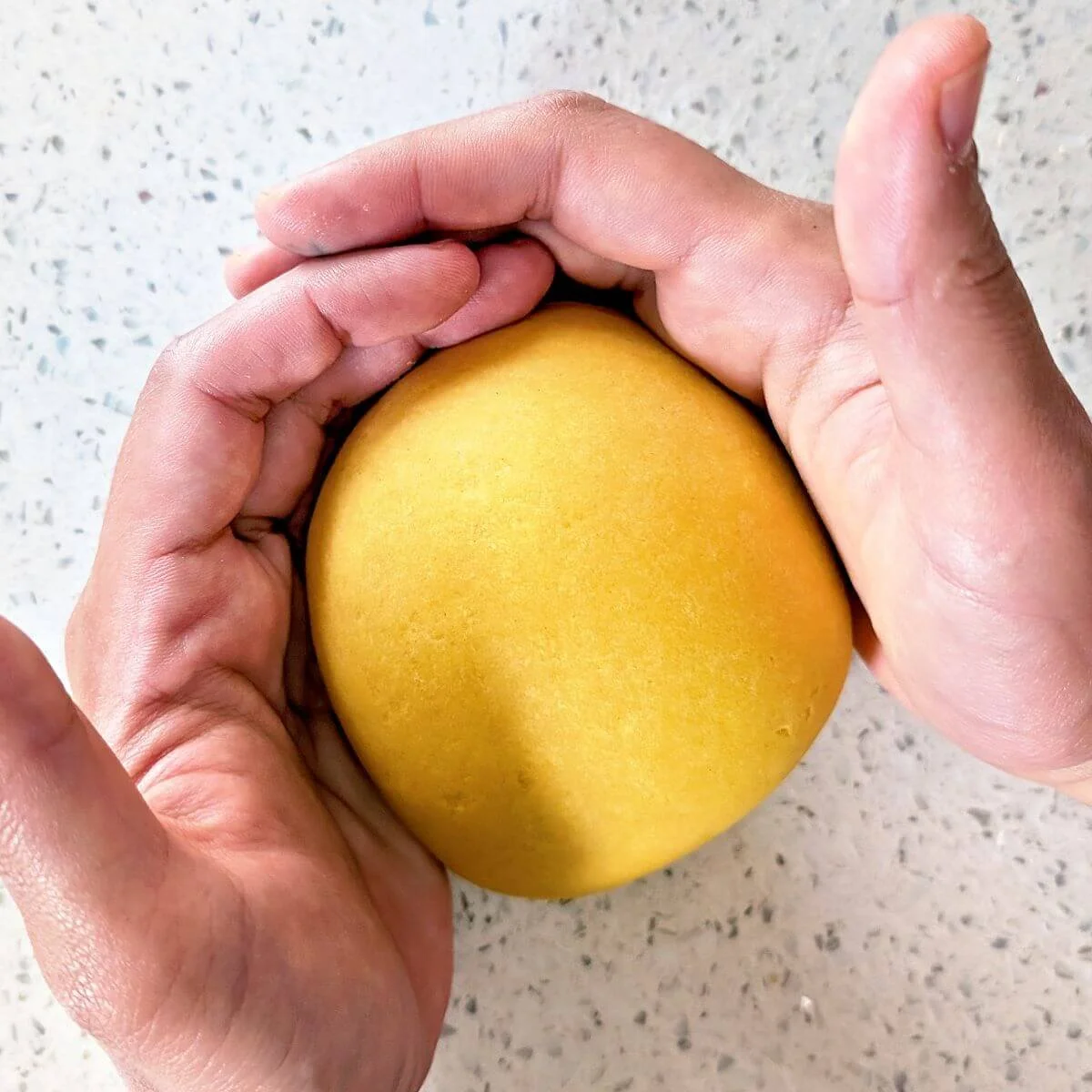 Smooth, tightly shaped ball of fresh pasta dough after full kneading