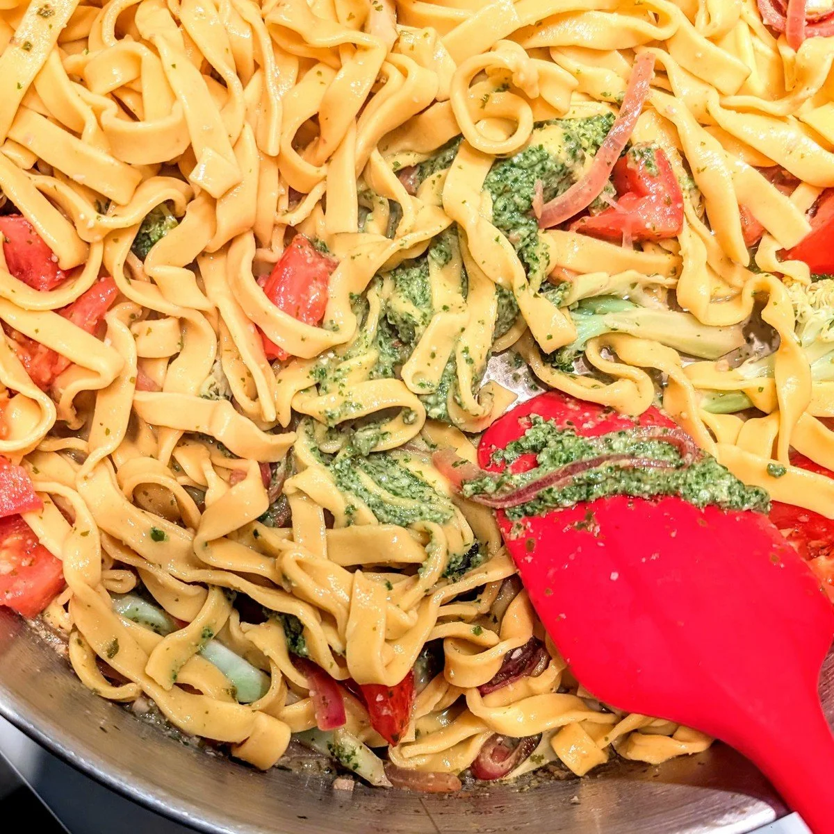 Fresh pasta with pesto sauce in a skillet