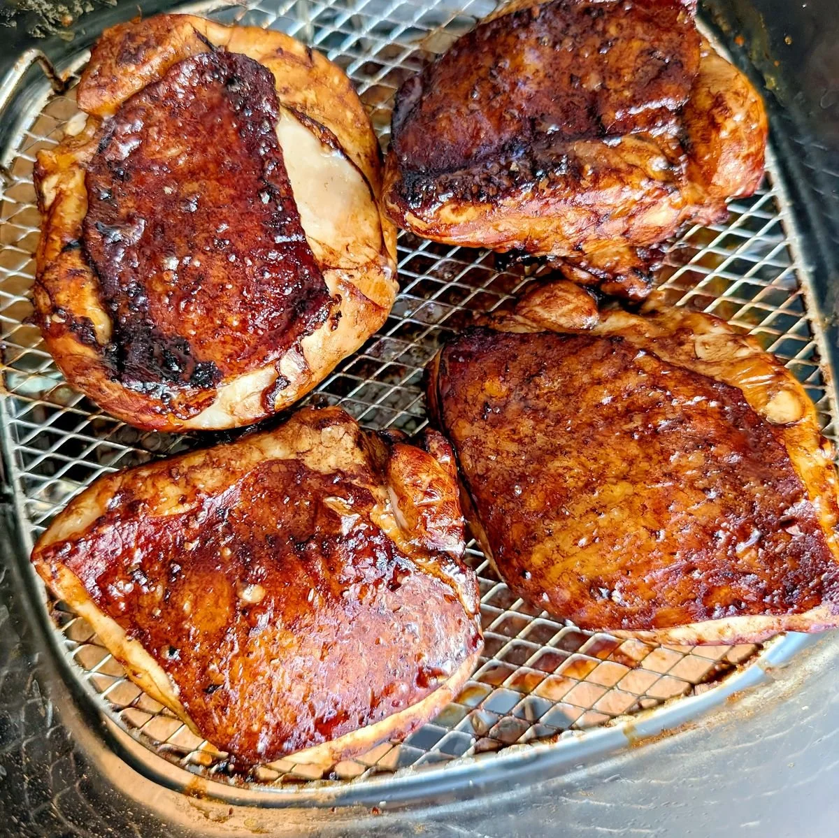 Fully cooked balsamic chicken thighs in the air fryer basket