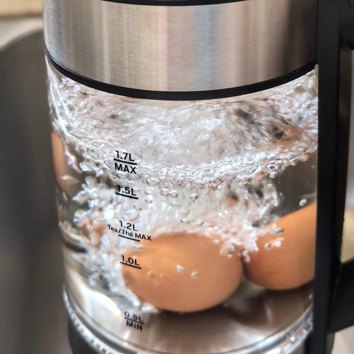 Adding cold water to an electric kettle to boil eggs