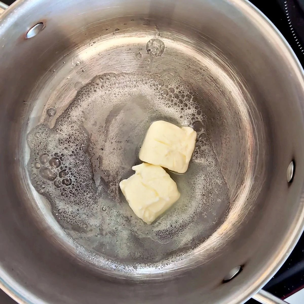 Butter melting in a saucepan to make a white roux for mornay sauce