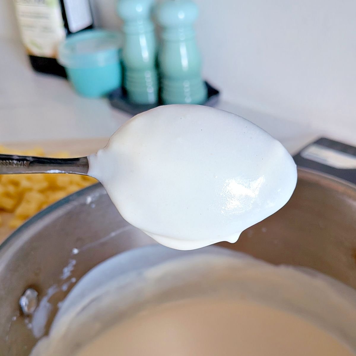 Sauce coating the back of a spoon during the nappe test for classic mornay sauce