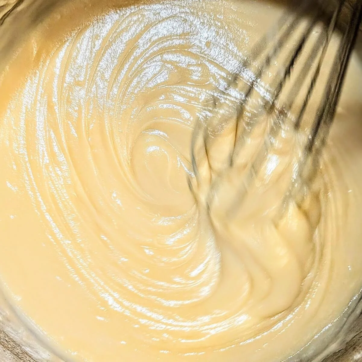 Smooth velouté sauce being whisked in a pot to make chicken pot pie filling