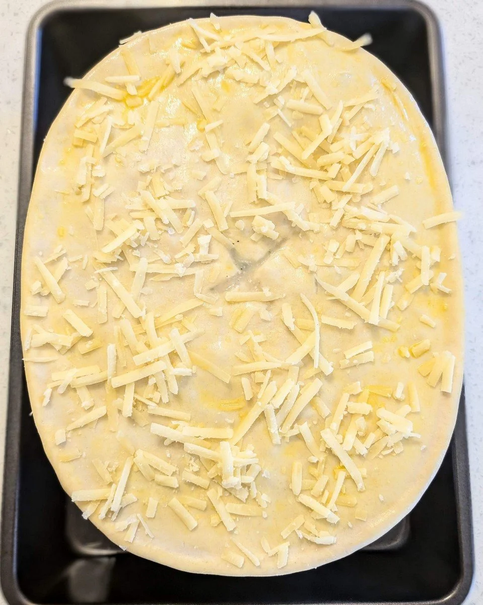 Gruyère cheese and flaky sea salt on a puff pastry crust for rotisserie chicken pot pie