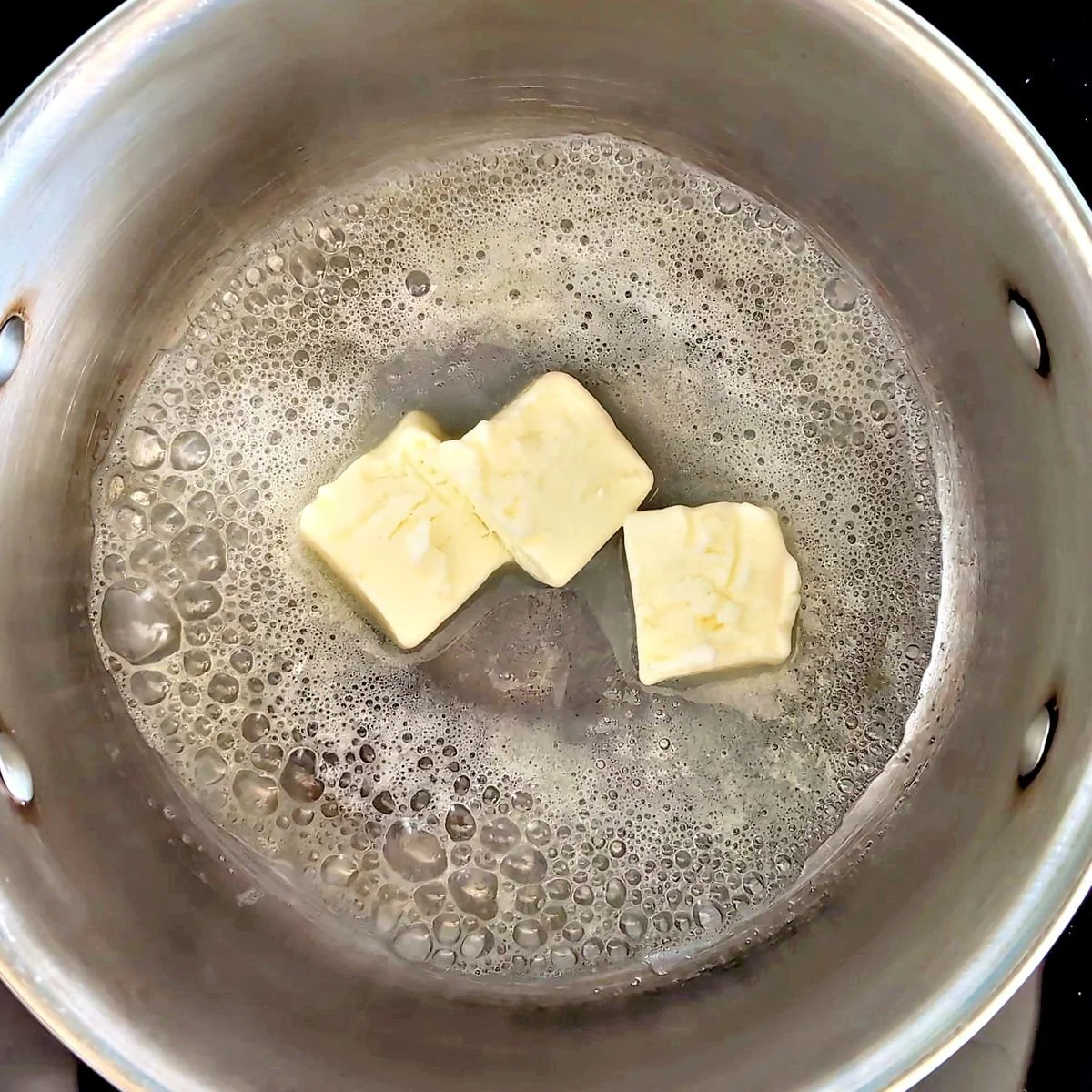 Butter melting in a saucepan to begin making a blond roux for velouté sauce