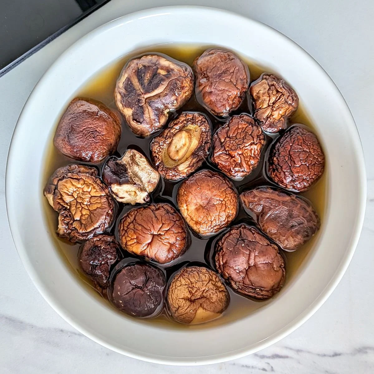 Dried shiitake mushrooms steeping in vegetable broth to make mushroom gravy