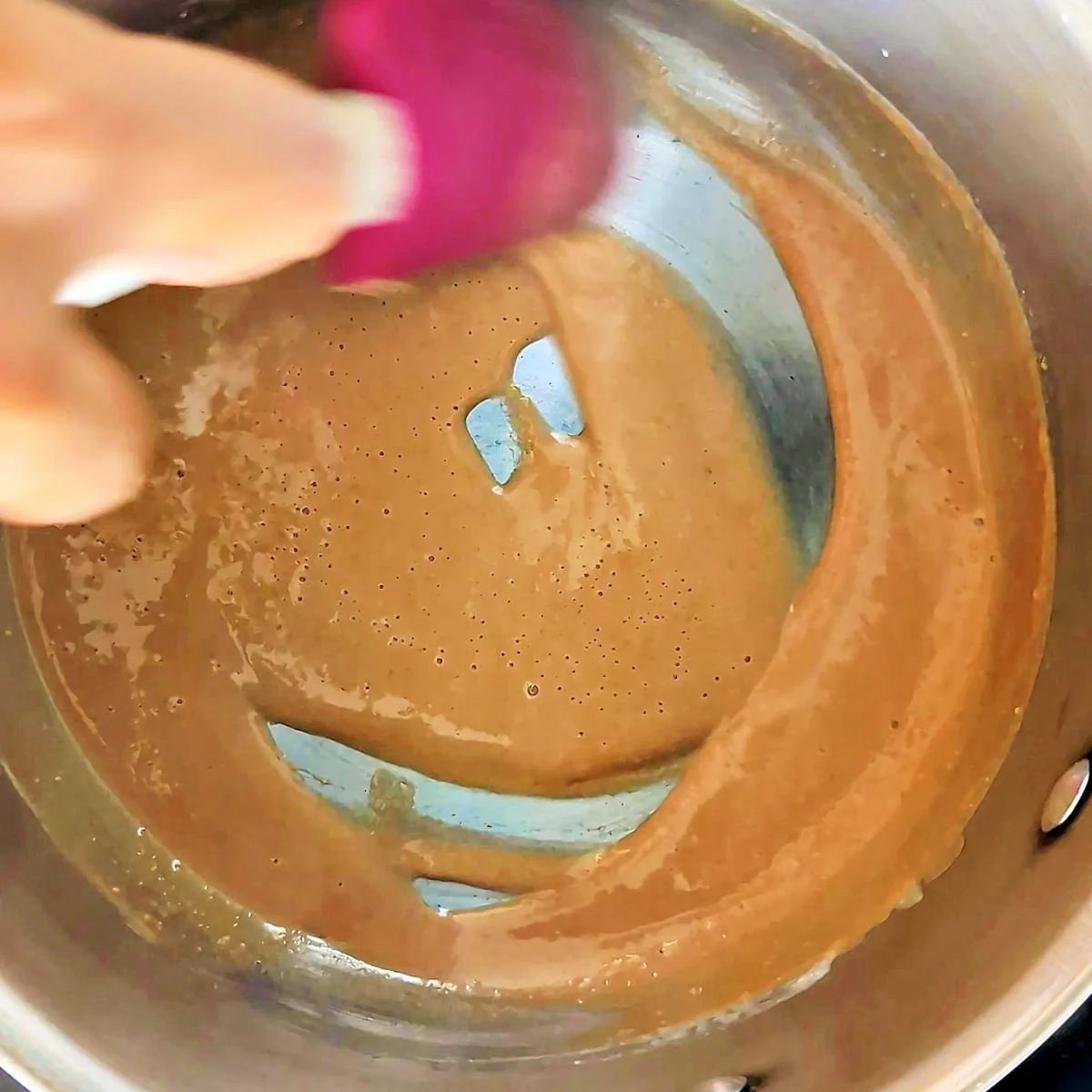 Brown roux with a deep brown color cooking in a saucepan