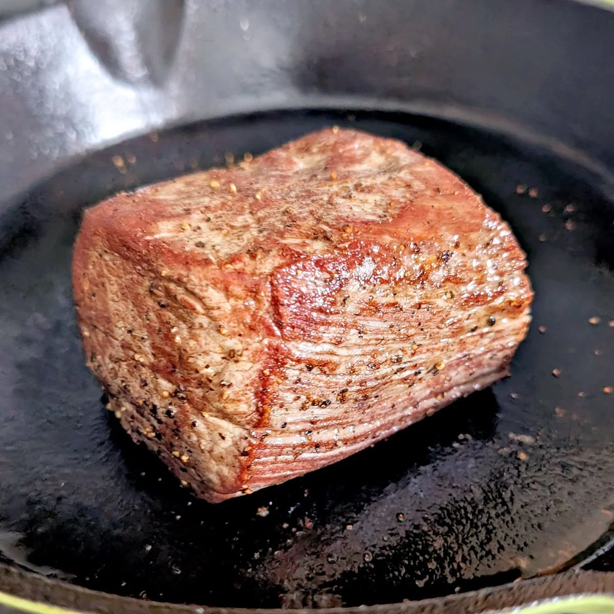 Seared beef tenderloin browned on all sides for beef Wellington