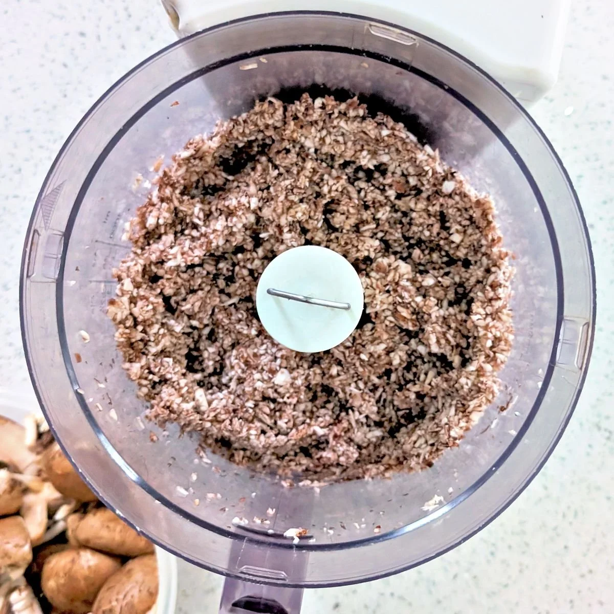 Finely chopped cremini mushrooms in a food processor for mushroom duxelles