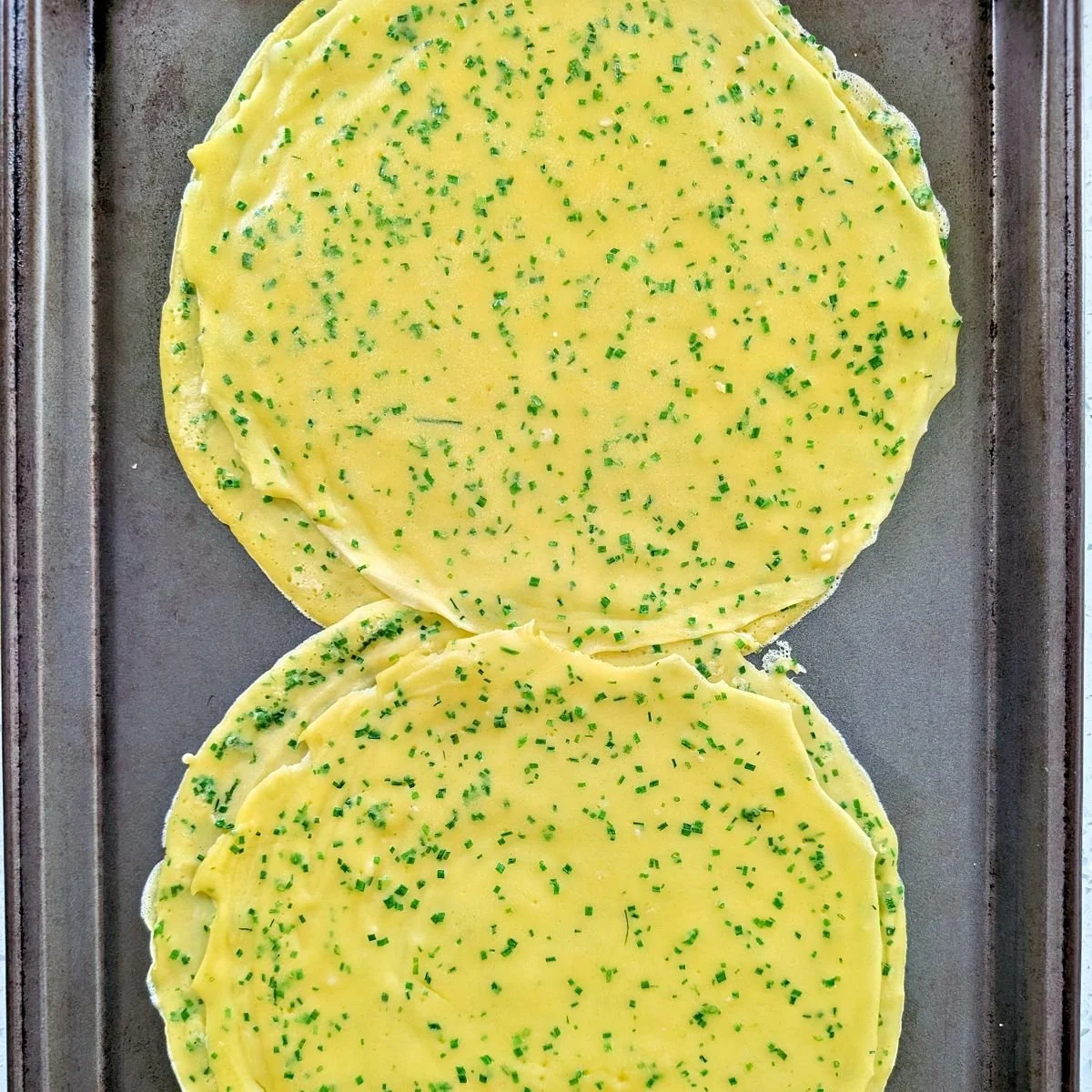 Finished thin chive crêpes cooling before wrapping beef Wellington
