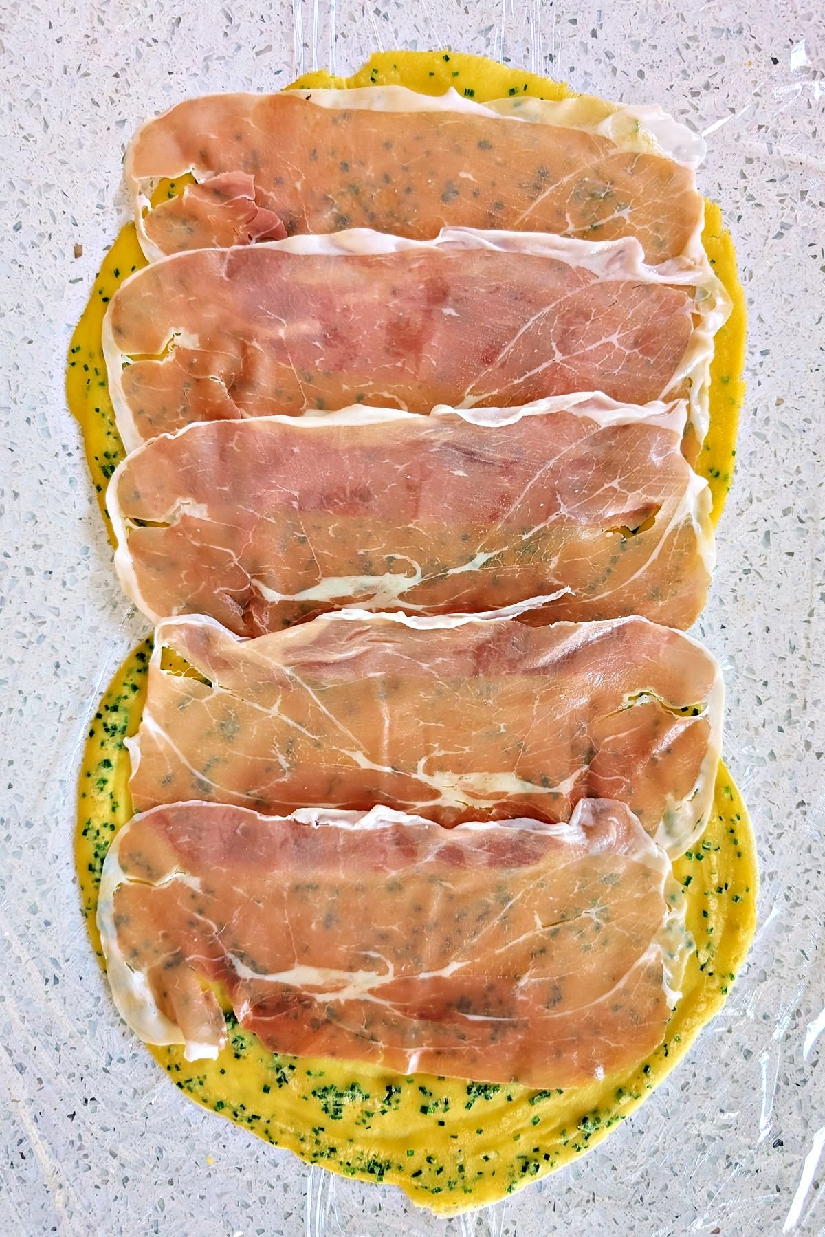 Prosciutto layered over chive crêpes for beef Wellington