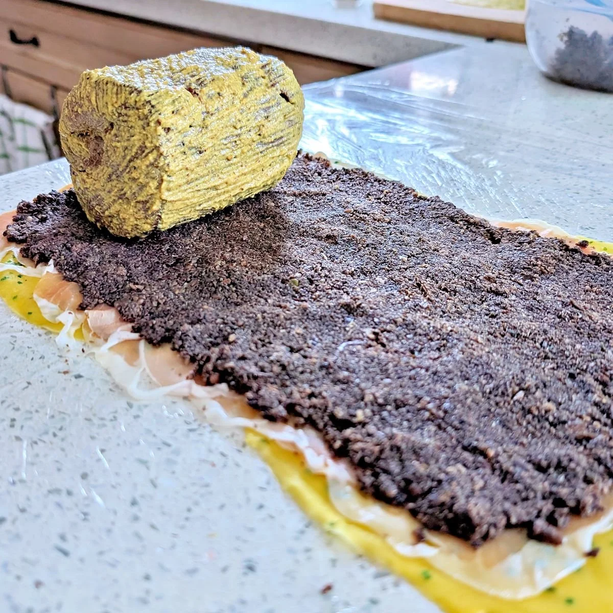 Mustard-coated beef tenderloin positioned on the mushroom duxelles