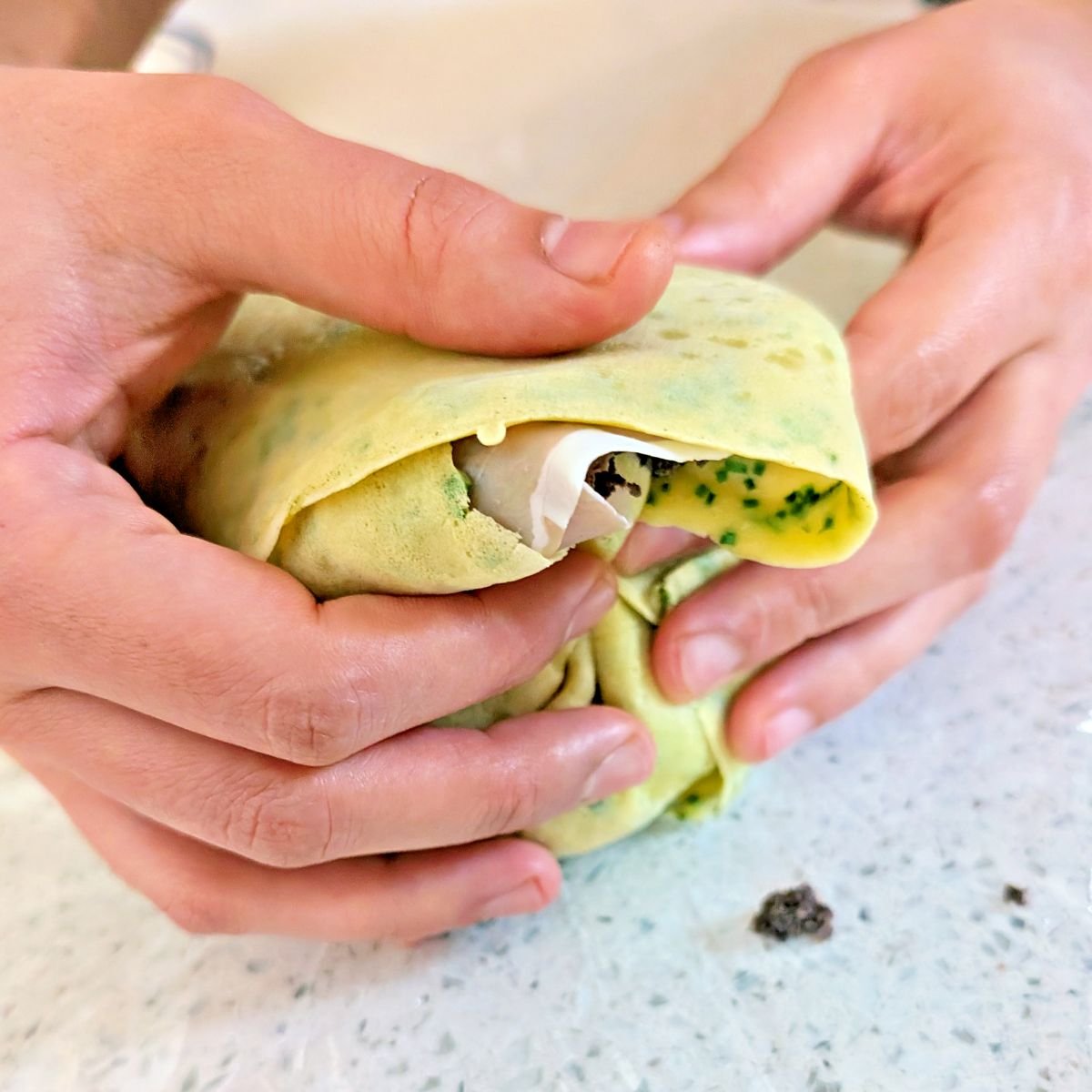 Open ends of the crêpes folded around the beef tenderloin