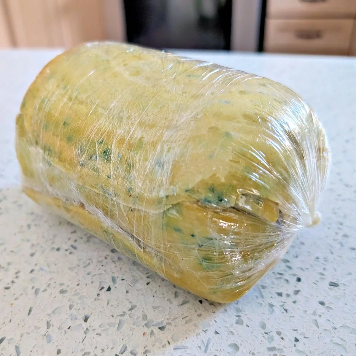 Wrapped beef Wellington filling tightly sealed in plastic wrap