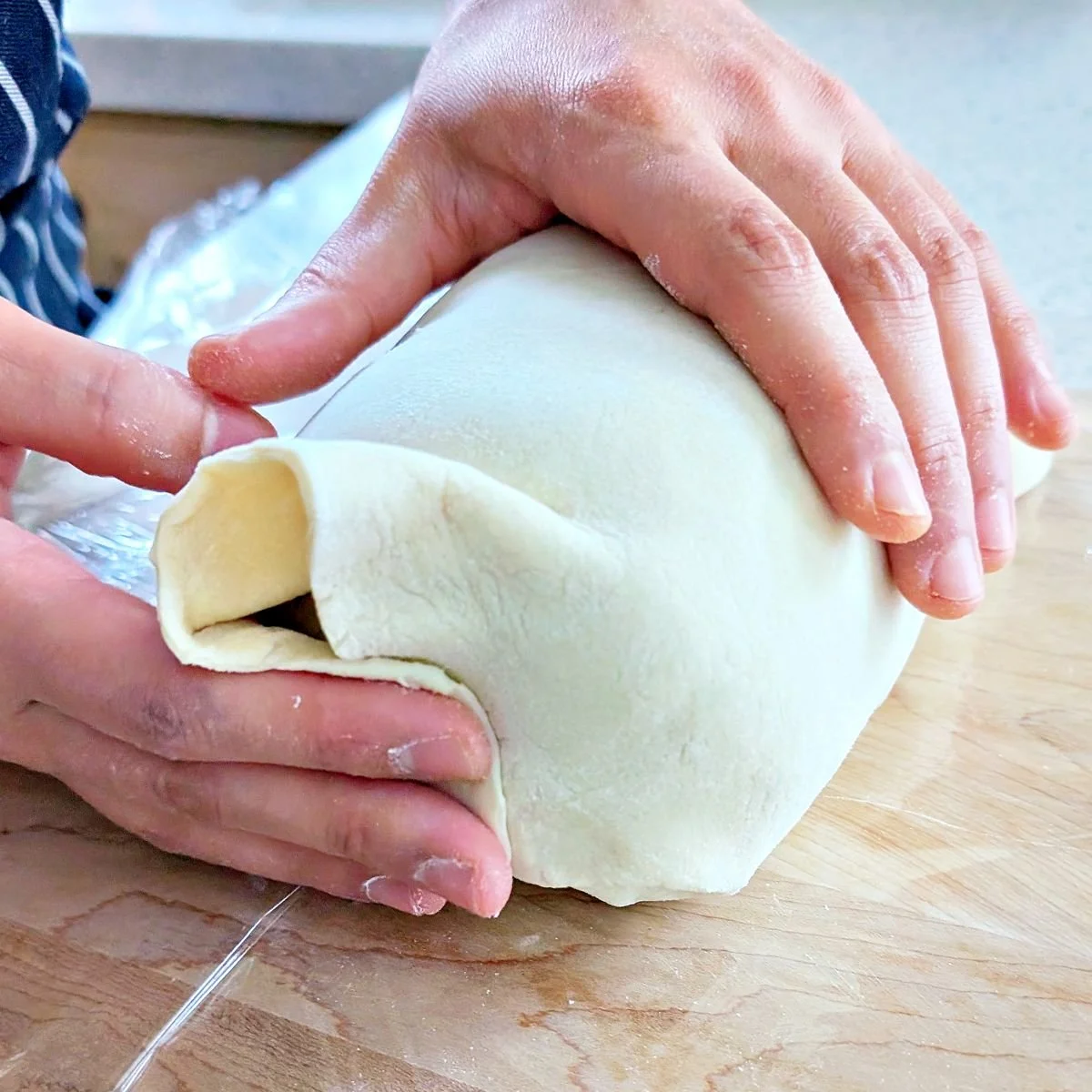Excess puff pastry folded upward at the end of the beef Wellington