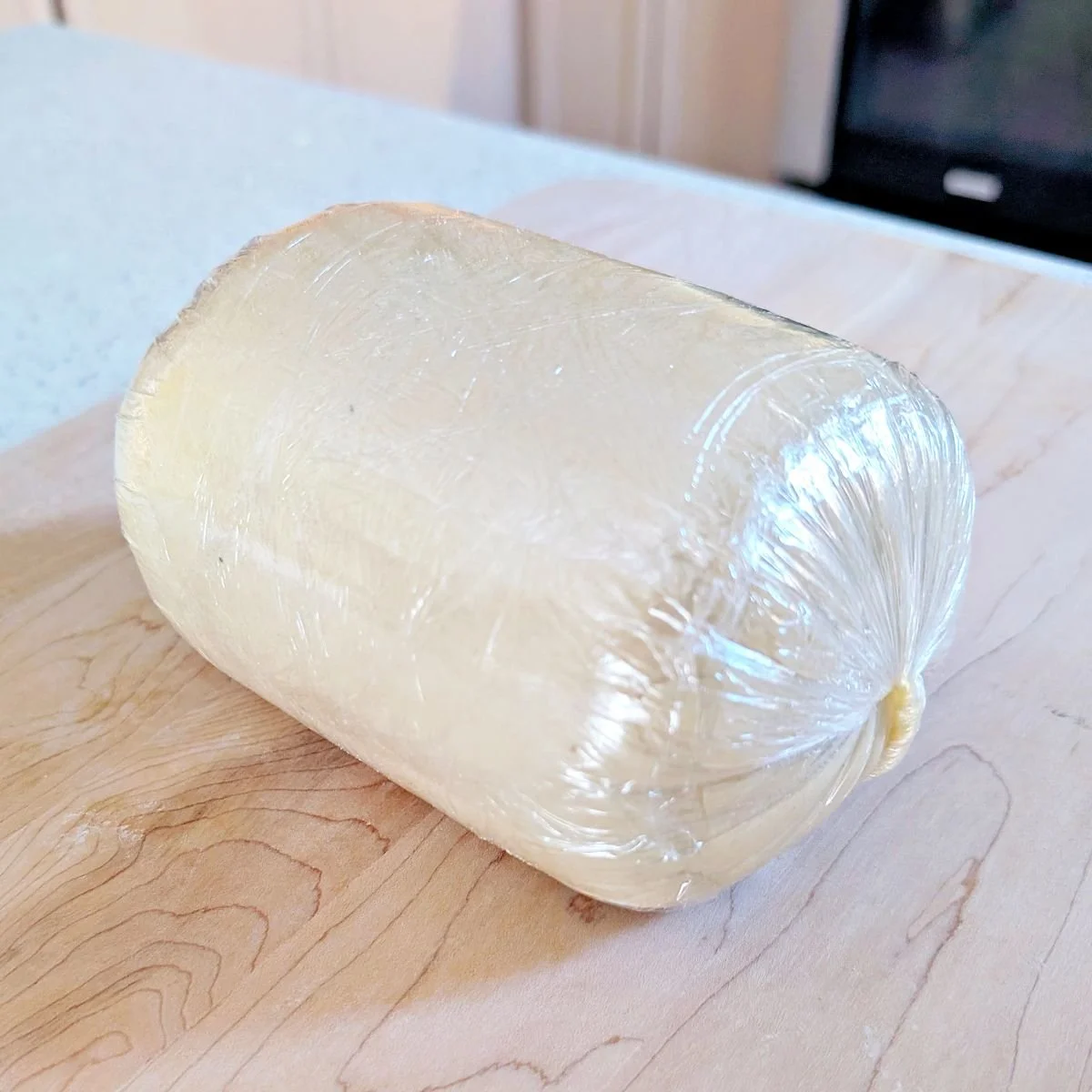 Beef Wellington tightly wrapped in plastic wrap after shaping