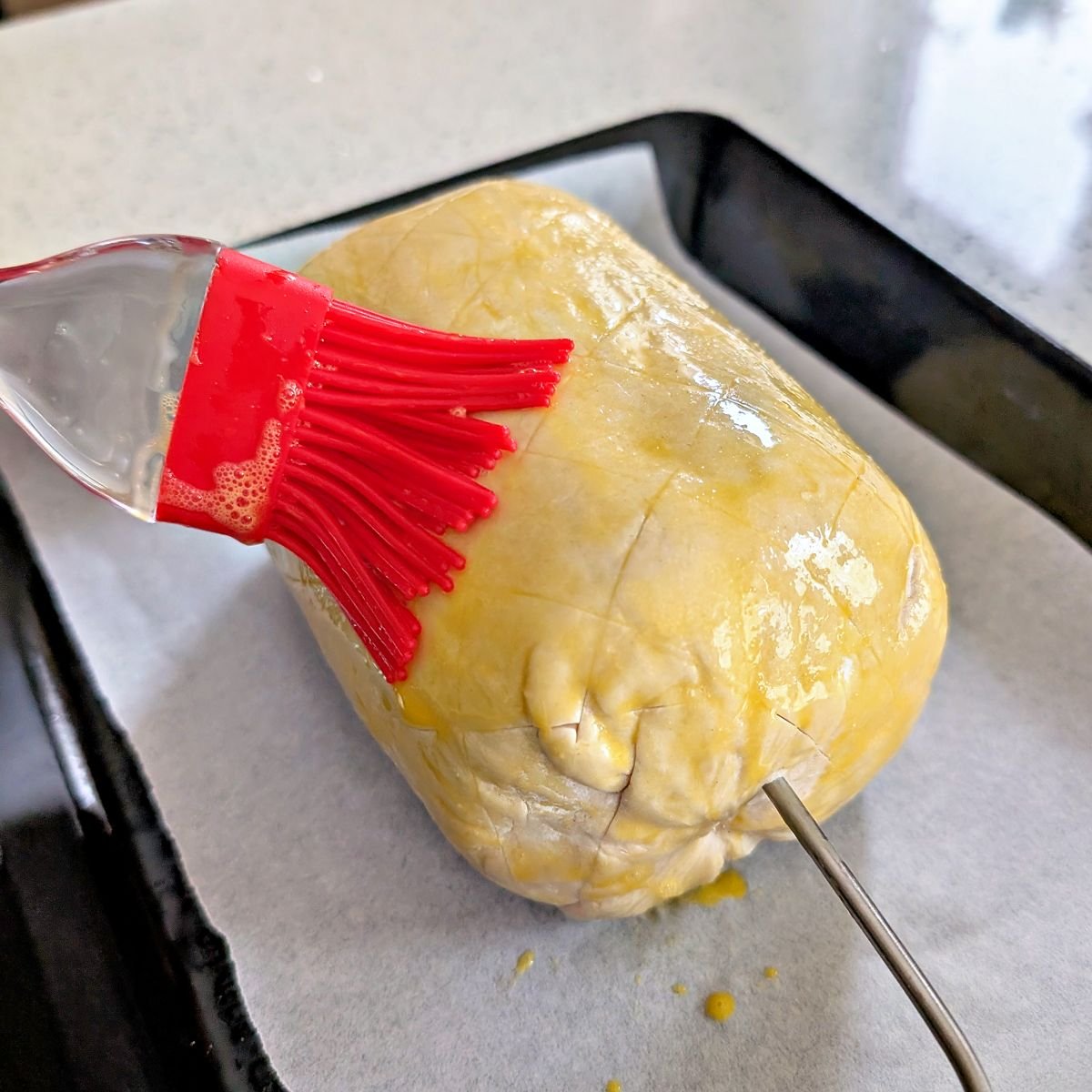 Egg wash brushed over the scored puff pastry