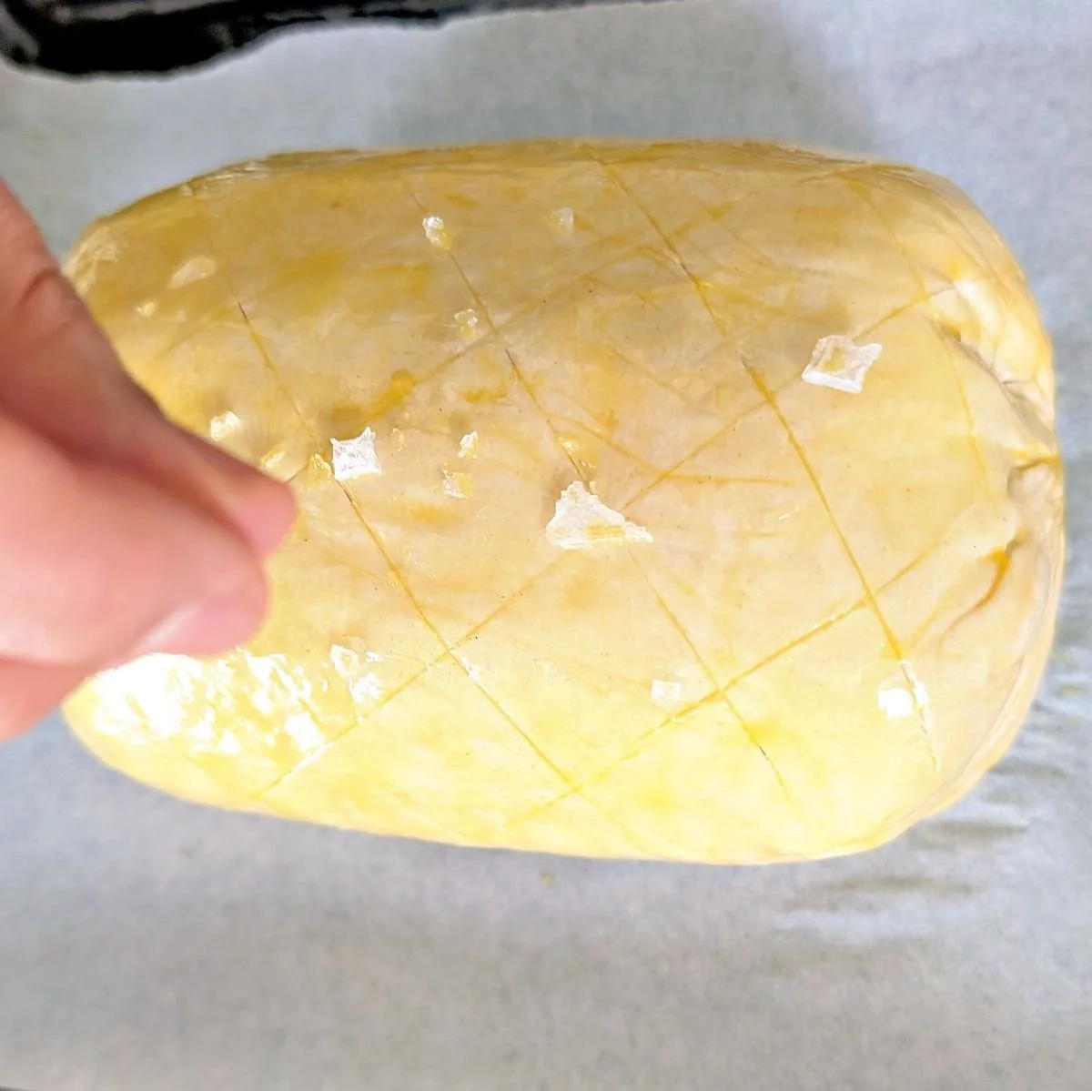 Beef Wellington with egg wash and flaky sea salt ready to bake