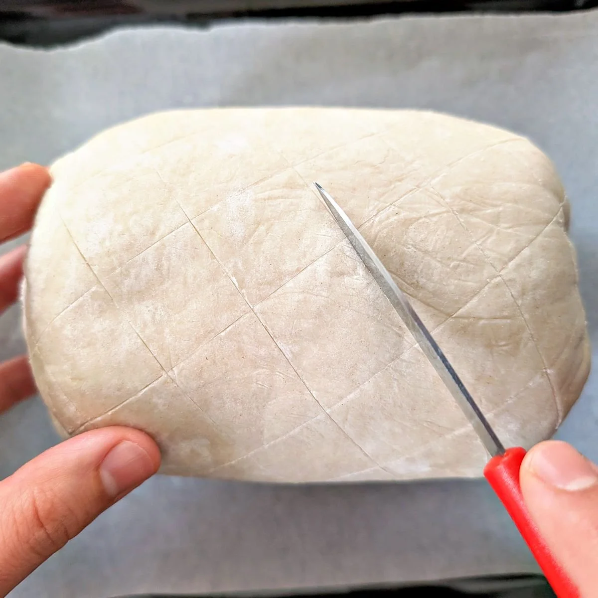 Crosshatch pattern scored into the puff pastry on beef Wellington