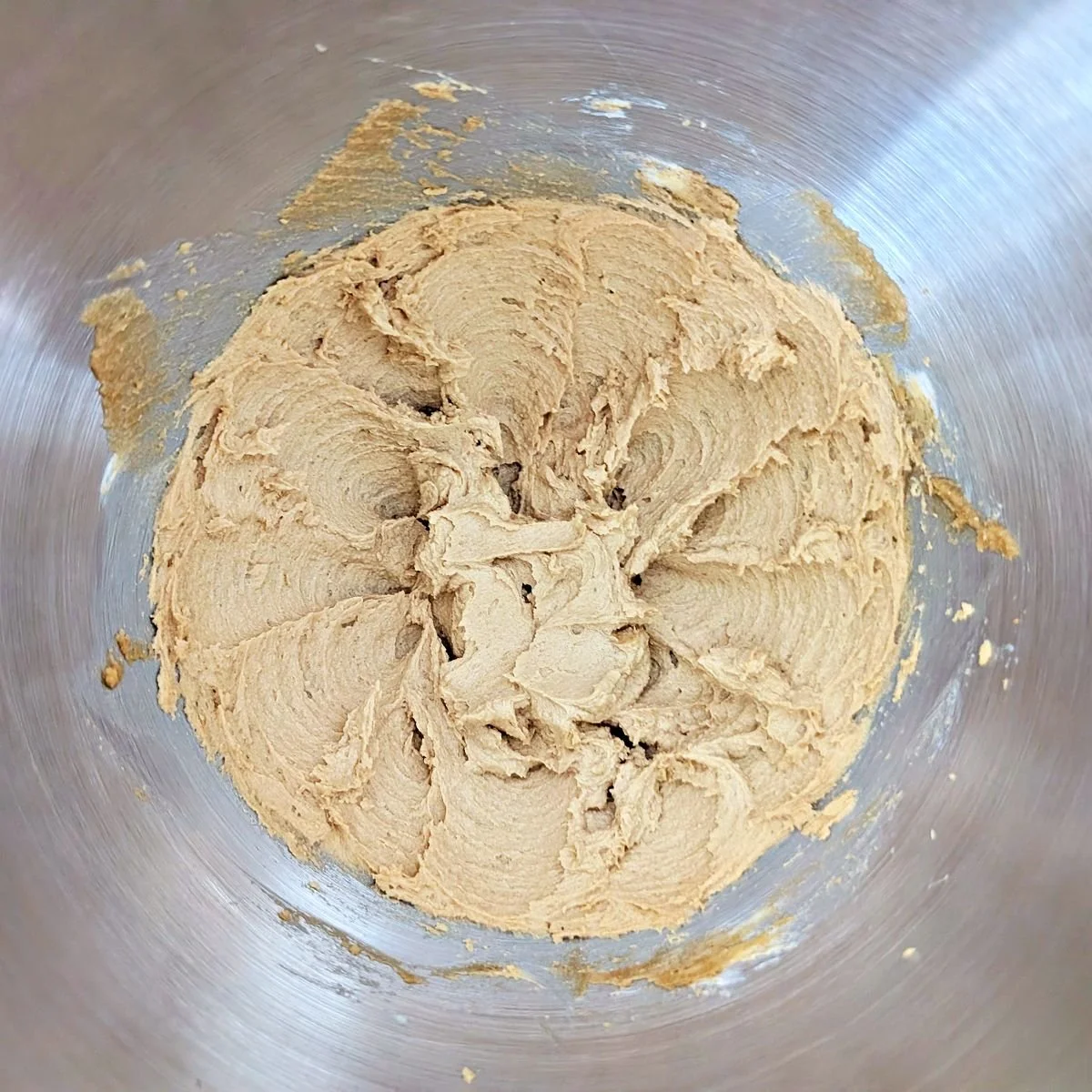 Creamed butter and brown sugar with a fluffy texture in a stand mixer bowl