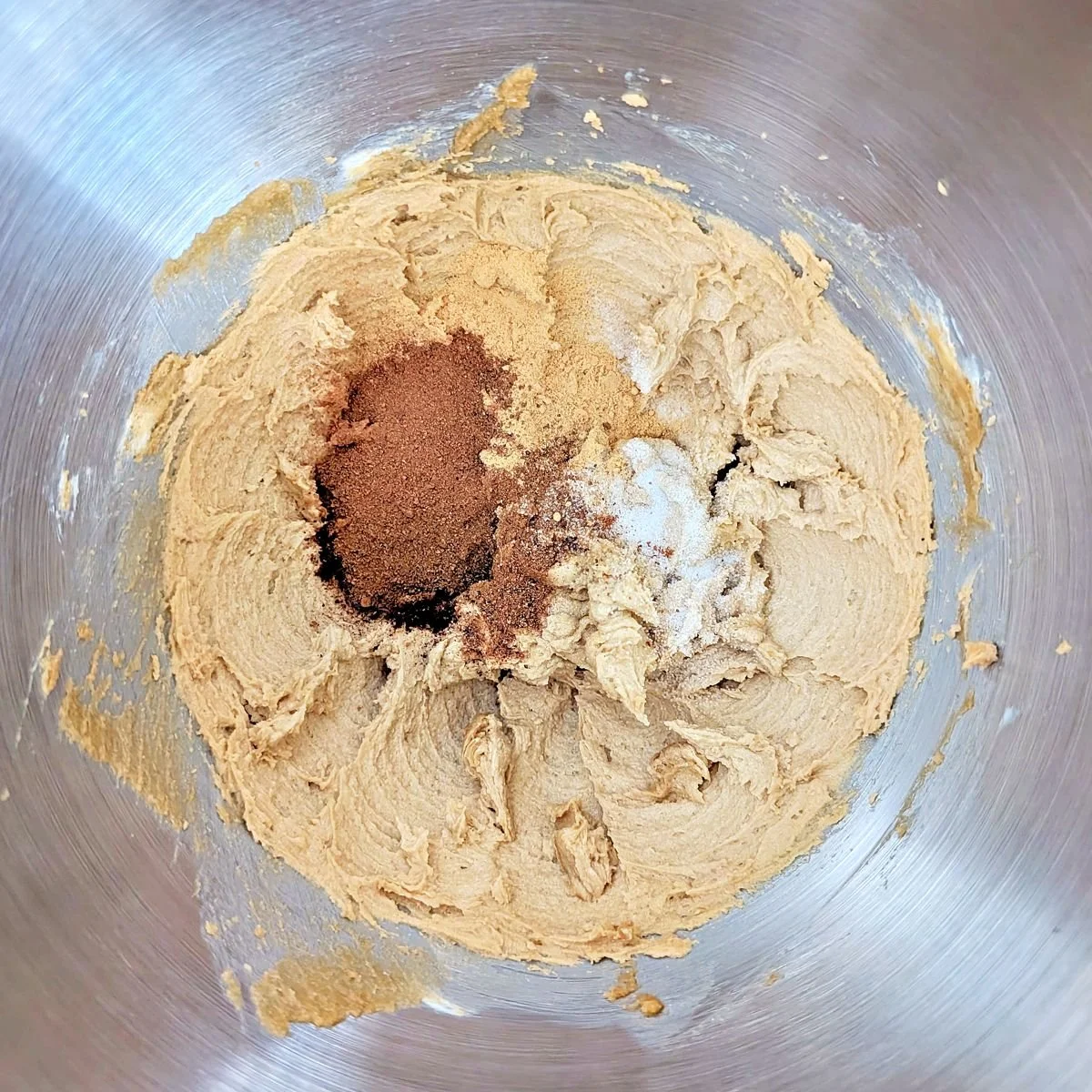 Spices added to creamed butter and brown sugar in a stand mixer bowl
