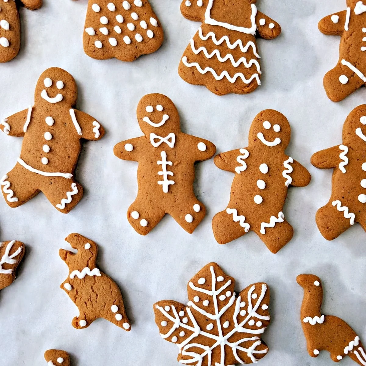 Decorated gingerbread people cookies with white royal icing in assorted designs