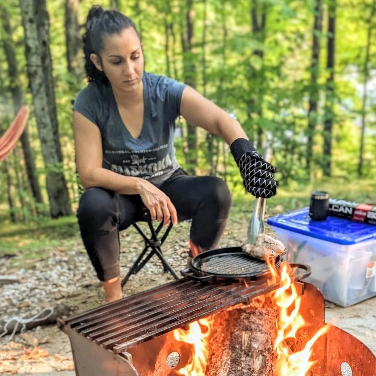 Chef Reem demonstrating how to cook duck breast over a campfire