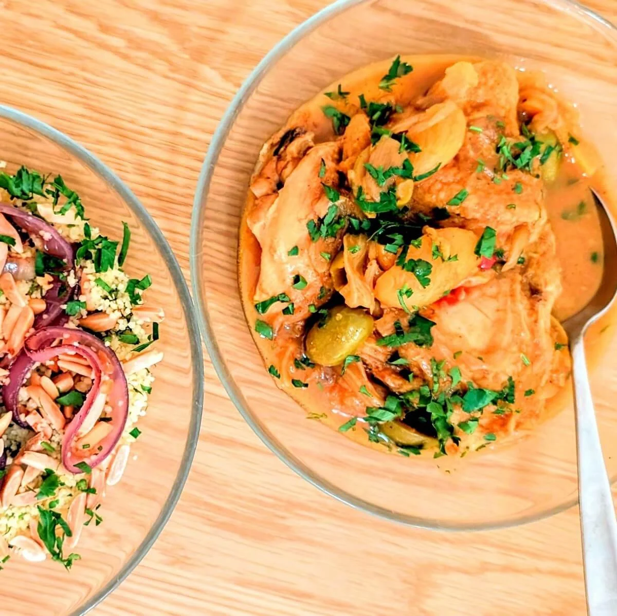 A bowl of Moroccan chicken couscous tagine served with couscous, caramelized onions, almonds, herbs, and preserved lemon dressing