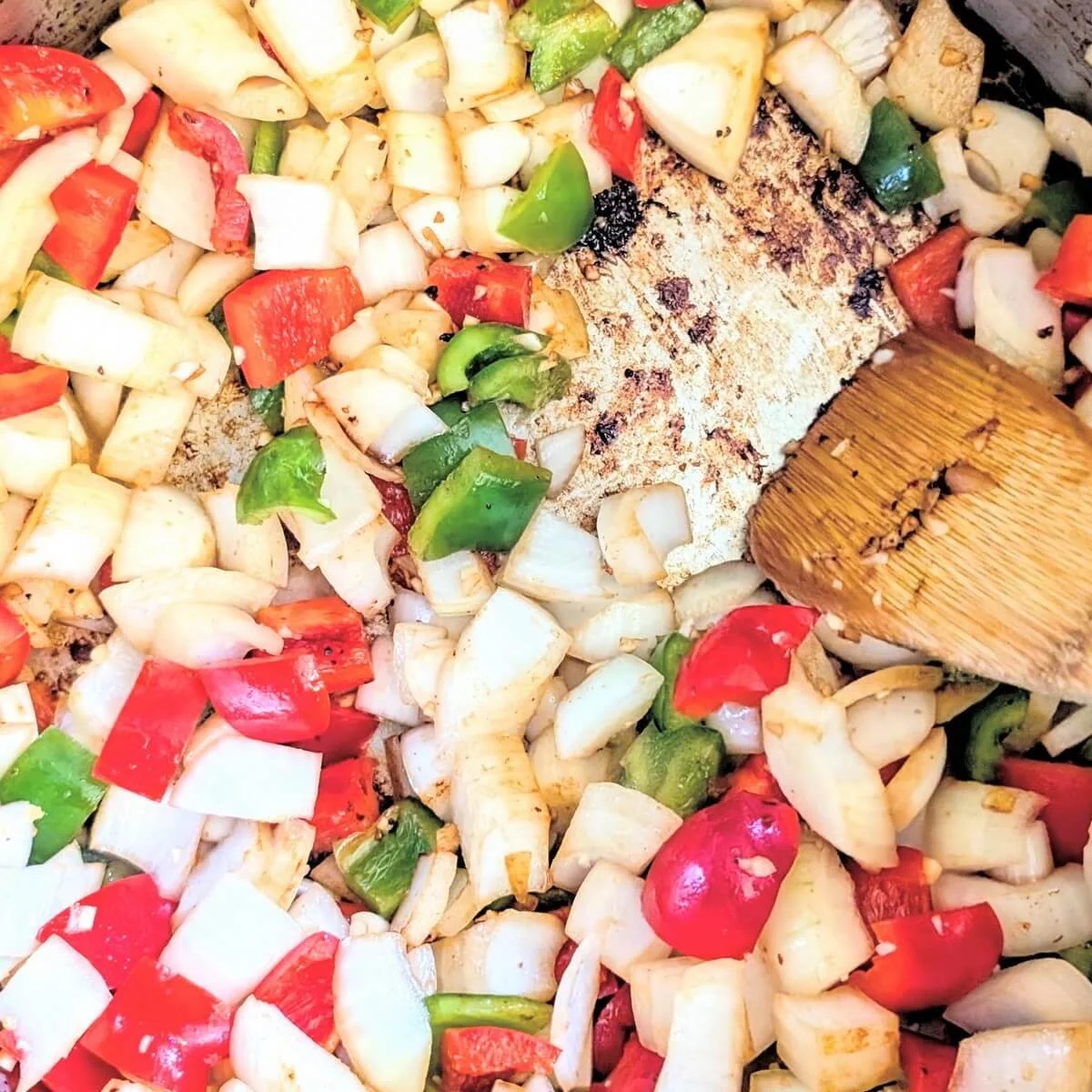Colorful peppers, onions, and garlic cooking in a pot for homemade chunky beef chilli recipe