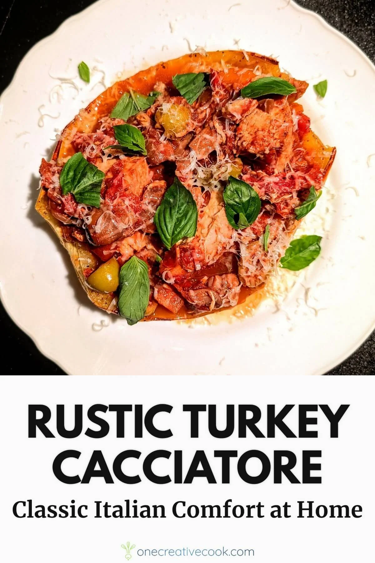 Plate of turkey cacciatore with braised turkey, tomato sauce, red peppers, olives, and fresh basil, served over roasted spaghetti squash and topped with grated parmesan