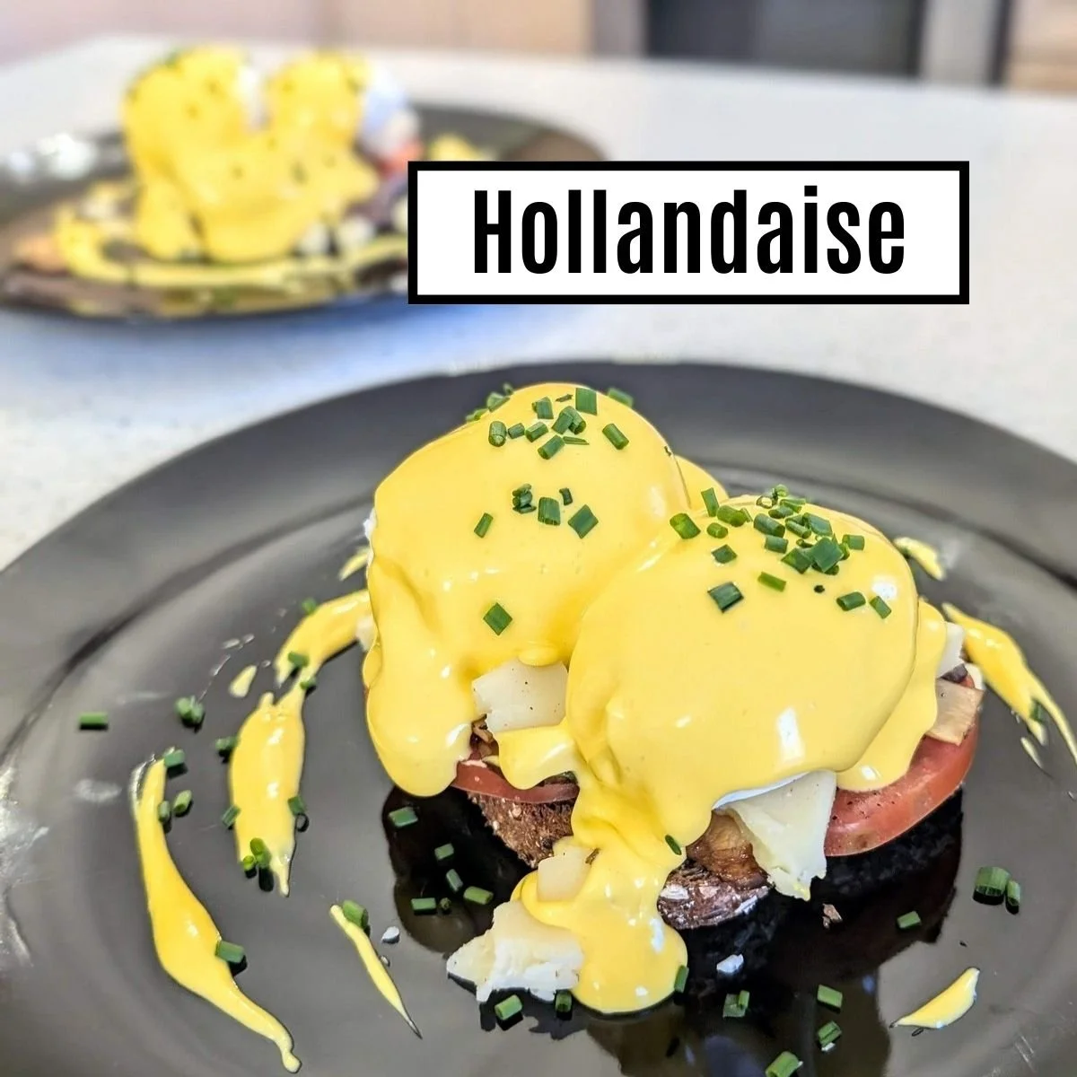 Immersion blender hollandaise mother sauce on vegetarian eggs benedict on two plates