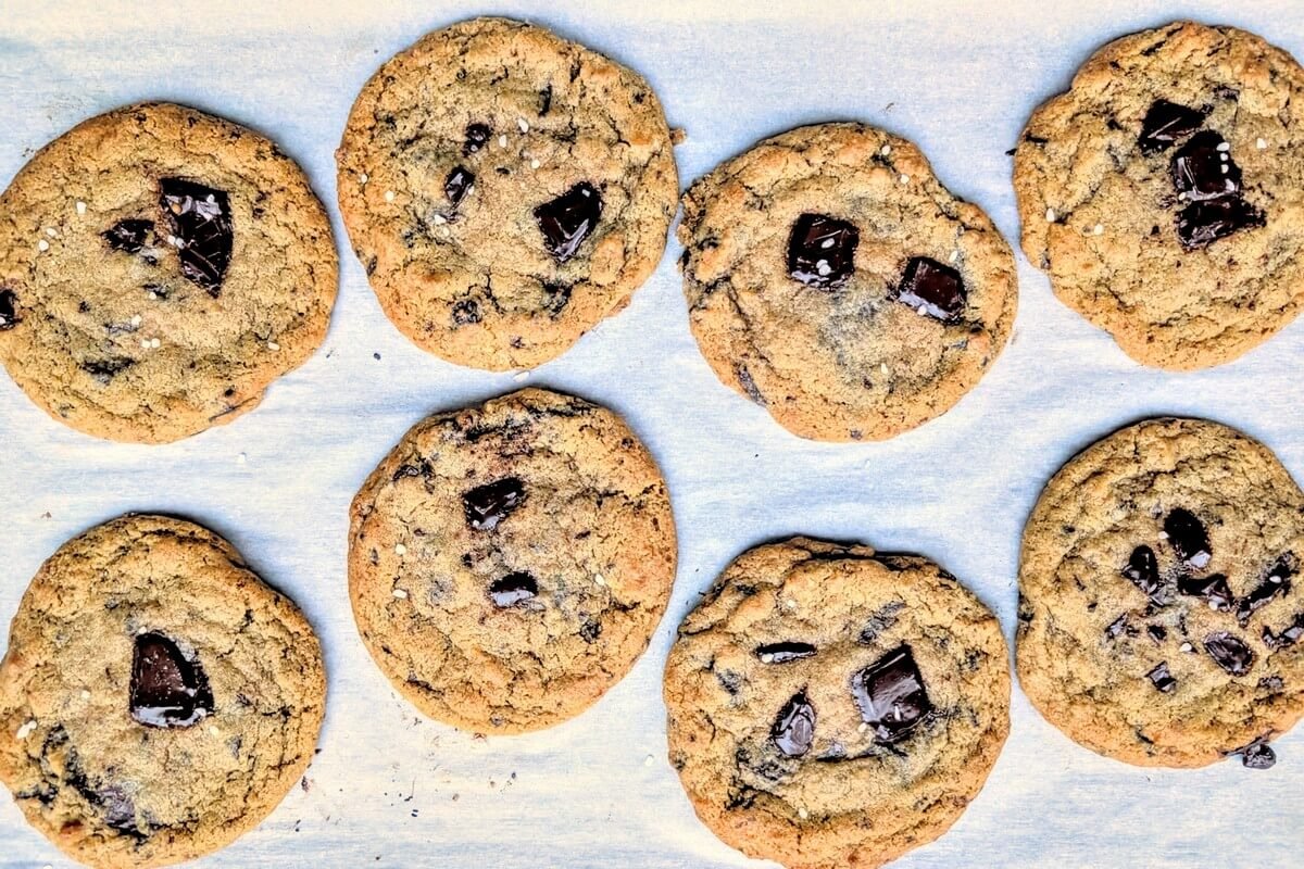 Overhead of gooey salted dark chocolate chip cookies cooling on a baking sheet
