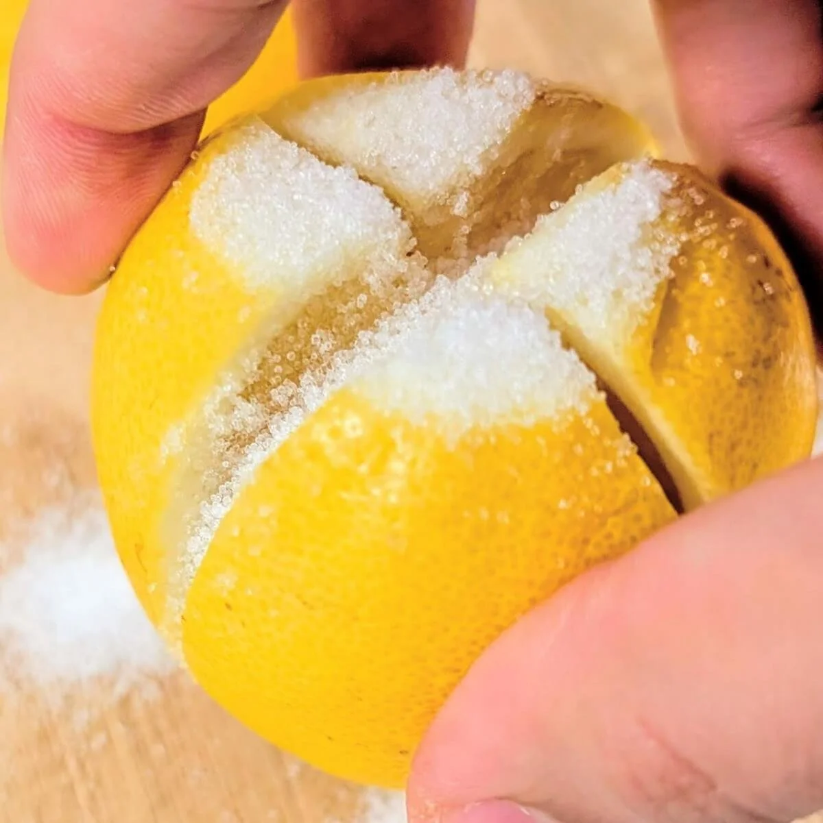 A lemon filled with salt being prepared for curing to make preserved lemons