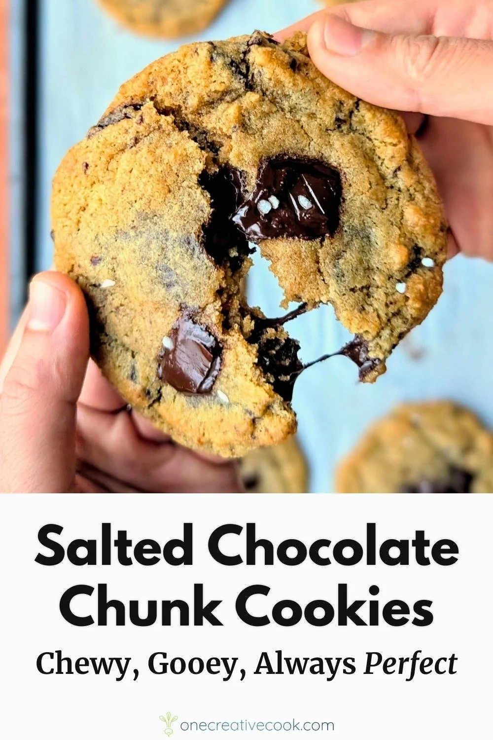 Salted dark chocolate chunk cookies being pulled apart and showing the gooey melted chocolate