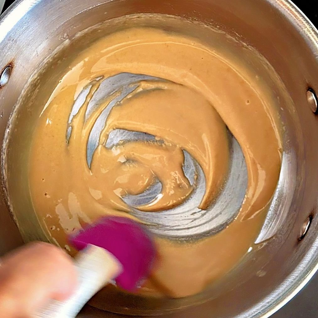 Making a blonde roux by stirring butter and flour together in a saucepan