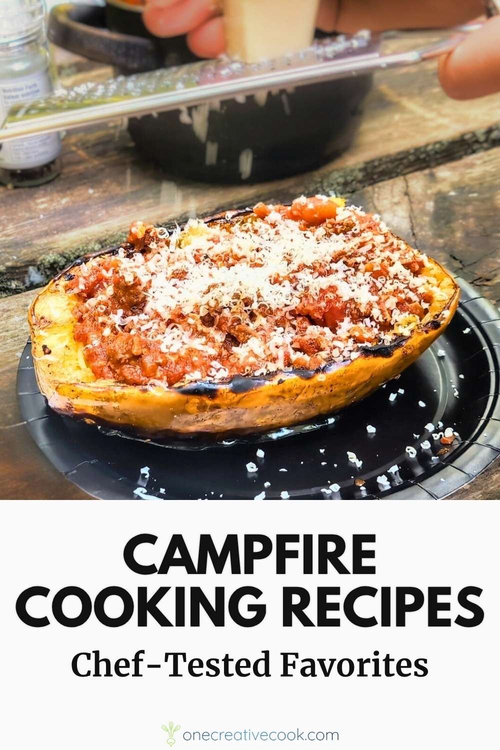 Parmesan being grated over fire-grilled spaghetti squash with meat sauce at a campsite, featured in a gourmet no foil camping recipes collection