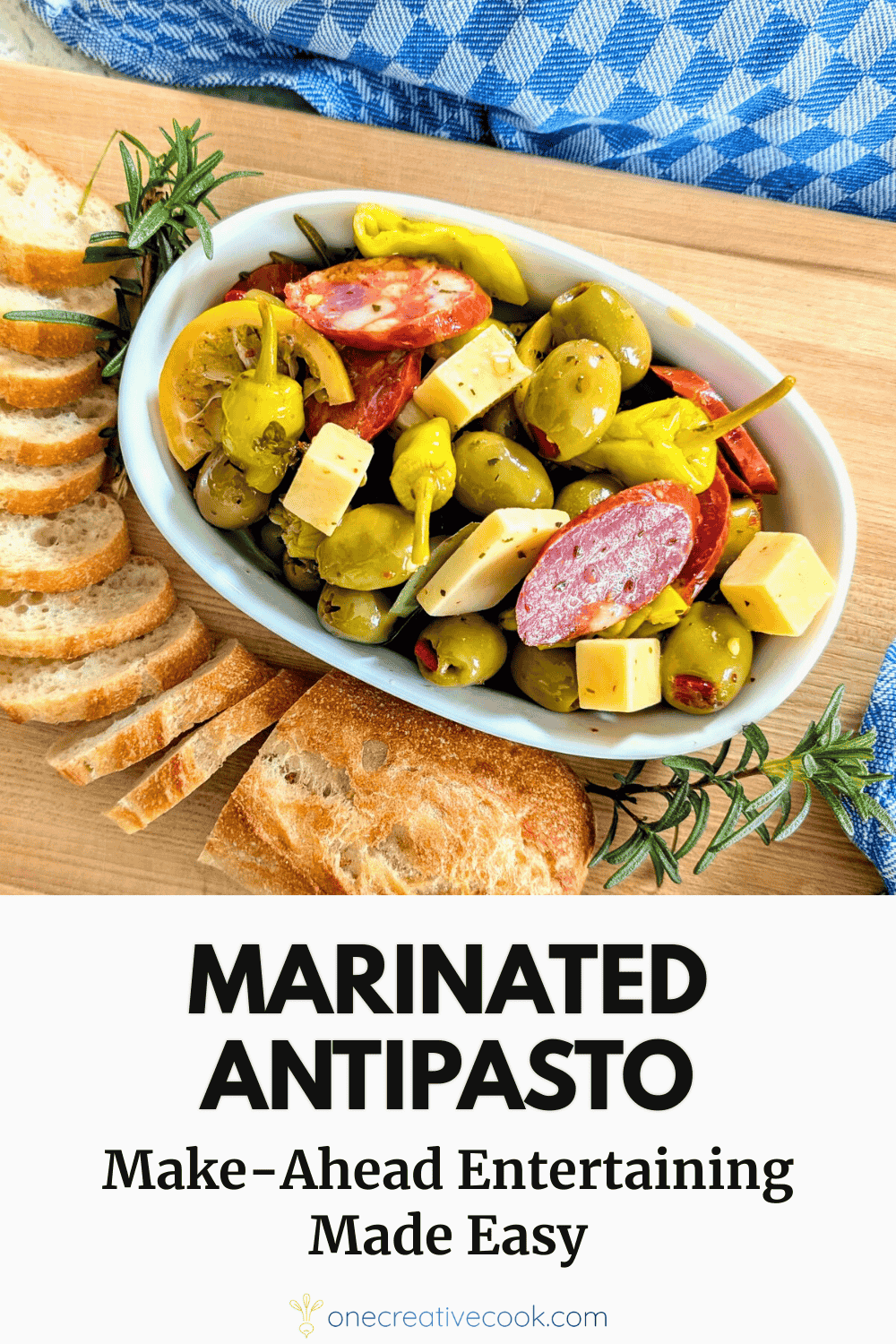 Marinated antipasto appetizer with cheese, olives, pepperoncini peppers, and chorizo sausage in a white bowl with bread on the side