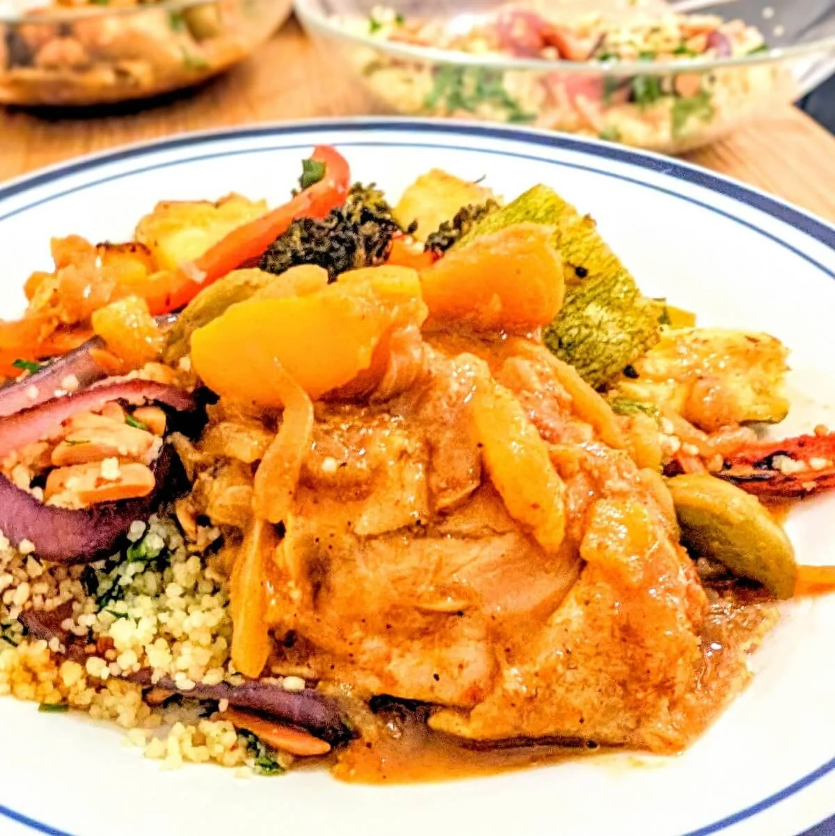Chicken lemon and olive tagine served with couscous and roasted vegetables on a plate