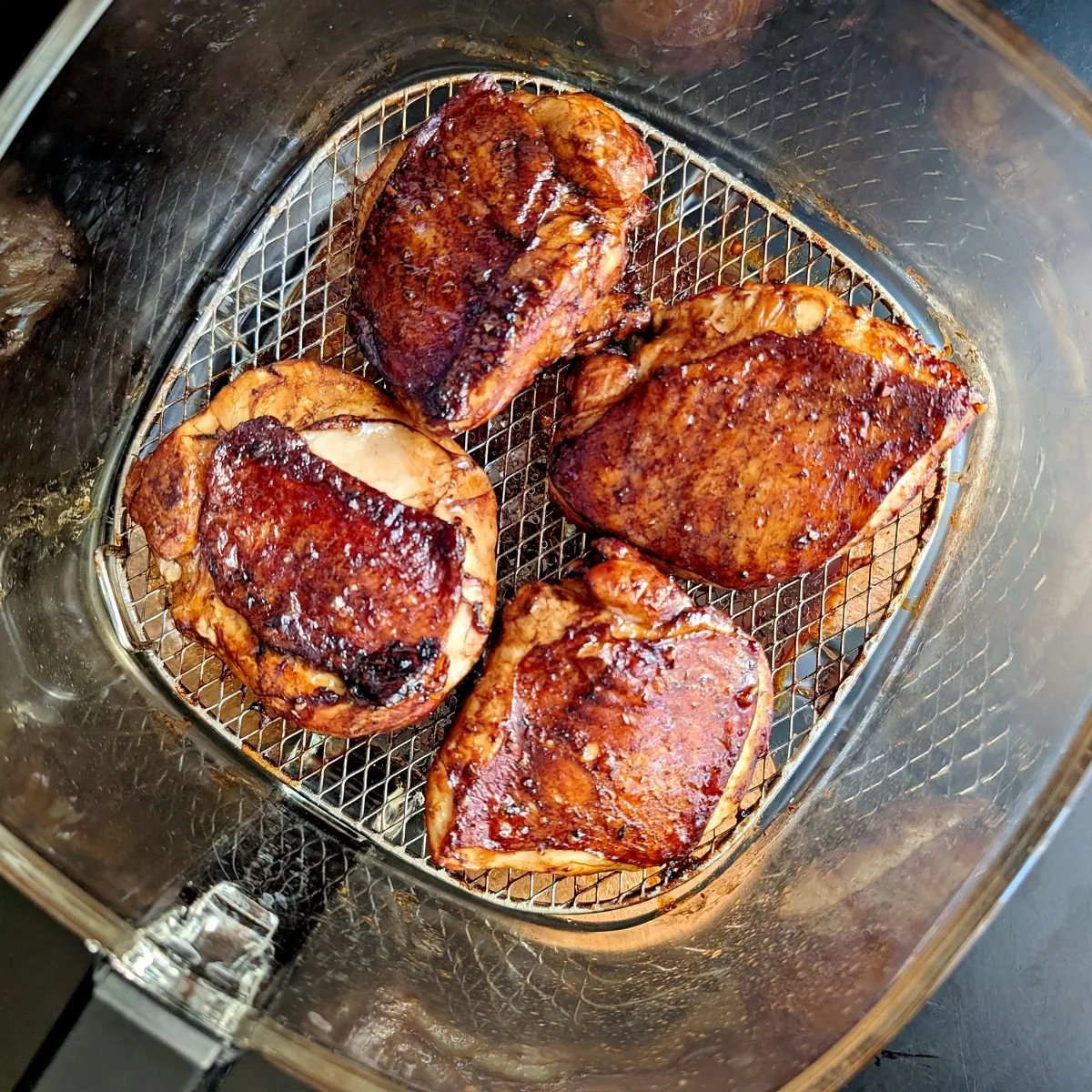 Caramelized balsamic chicken thighs in air fryer basket