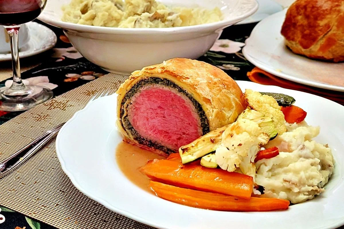 Beef Wellington served with mashed potatoes, roasted vegetables, and gravy