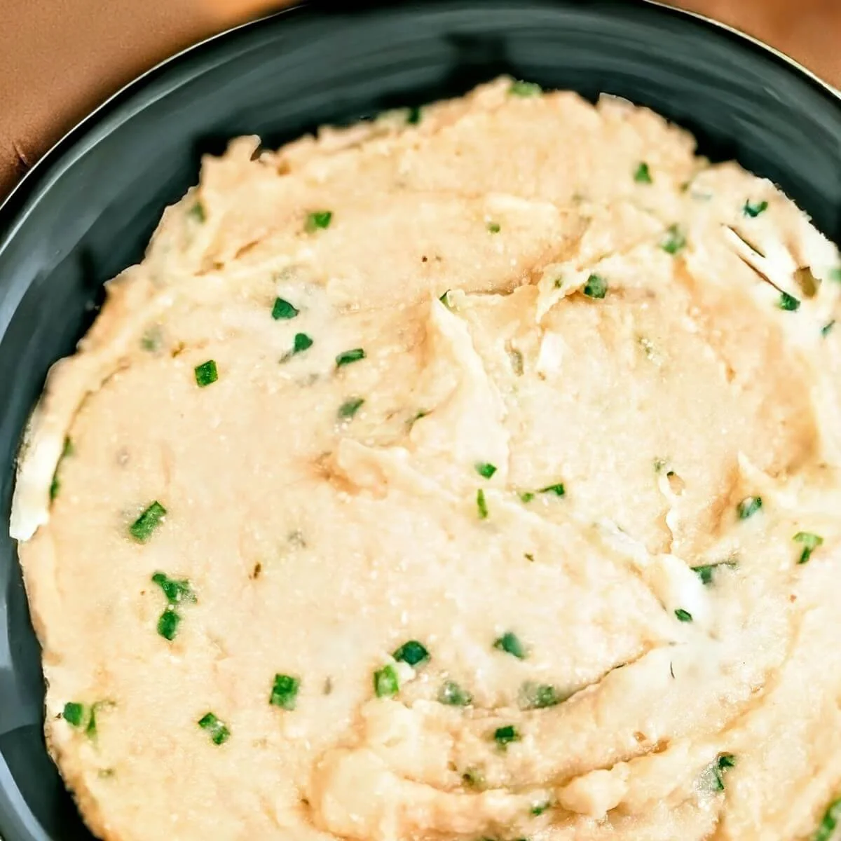 Creamy cauliflower and white bean mash with chives, served in a bowl for Christmas dinner