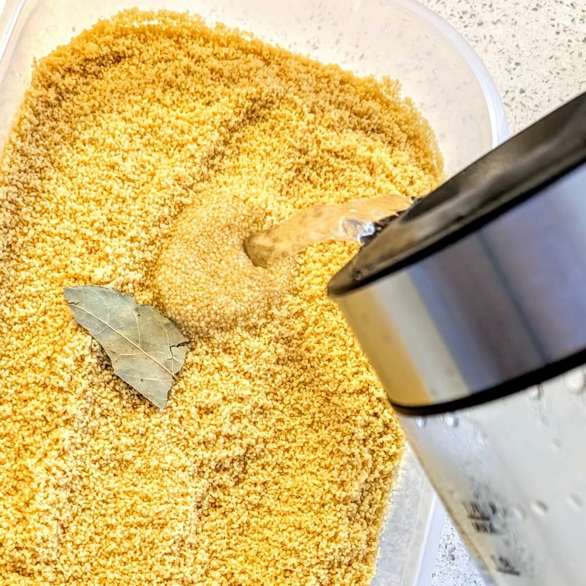 Boiling water being poured over North African couscous using the kettle method