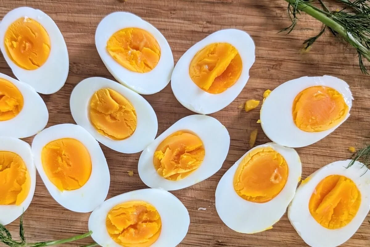 Kettle boiled eggs for making egg salad, cut in half, on a wooden cutting board