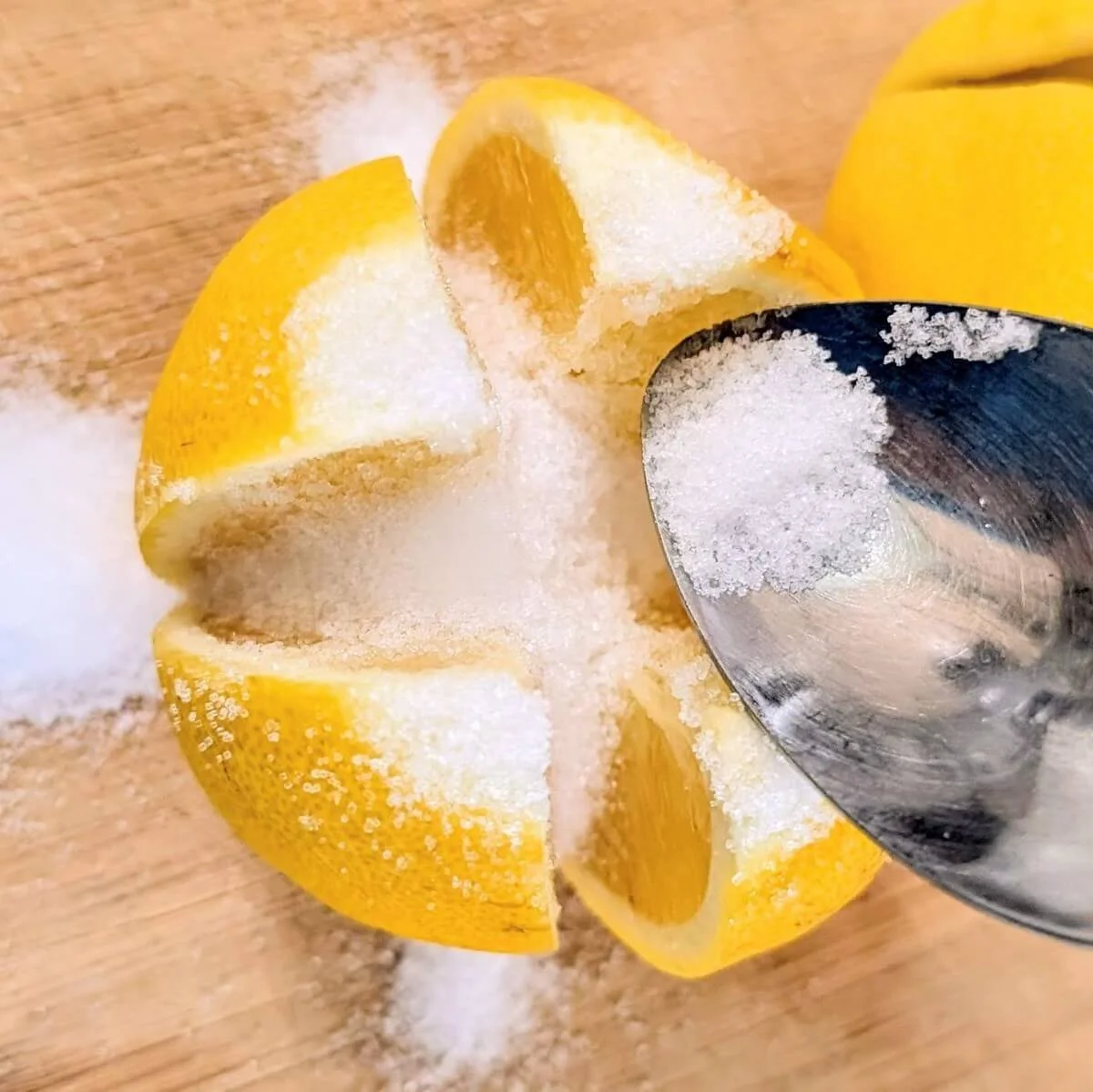 Sliced open lemon with salt being added to it for preserving