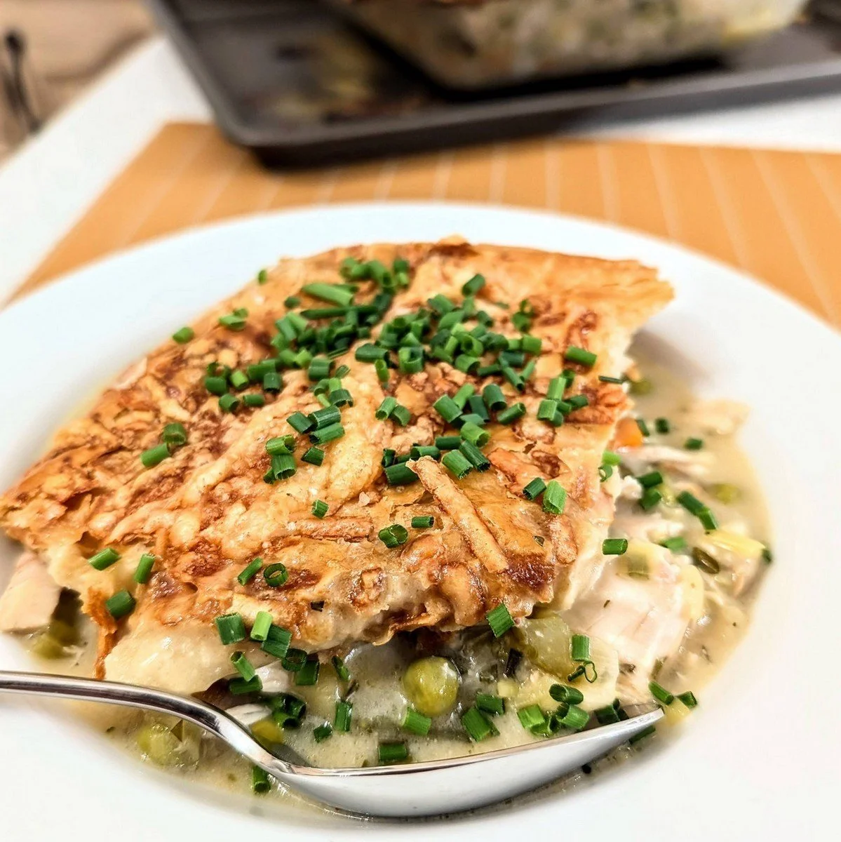 A portion of rotisserie chicken pot pie in a bowl with a spoon