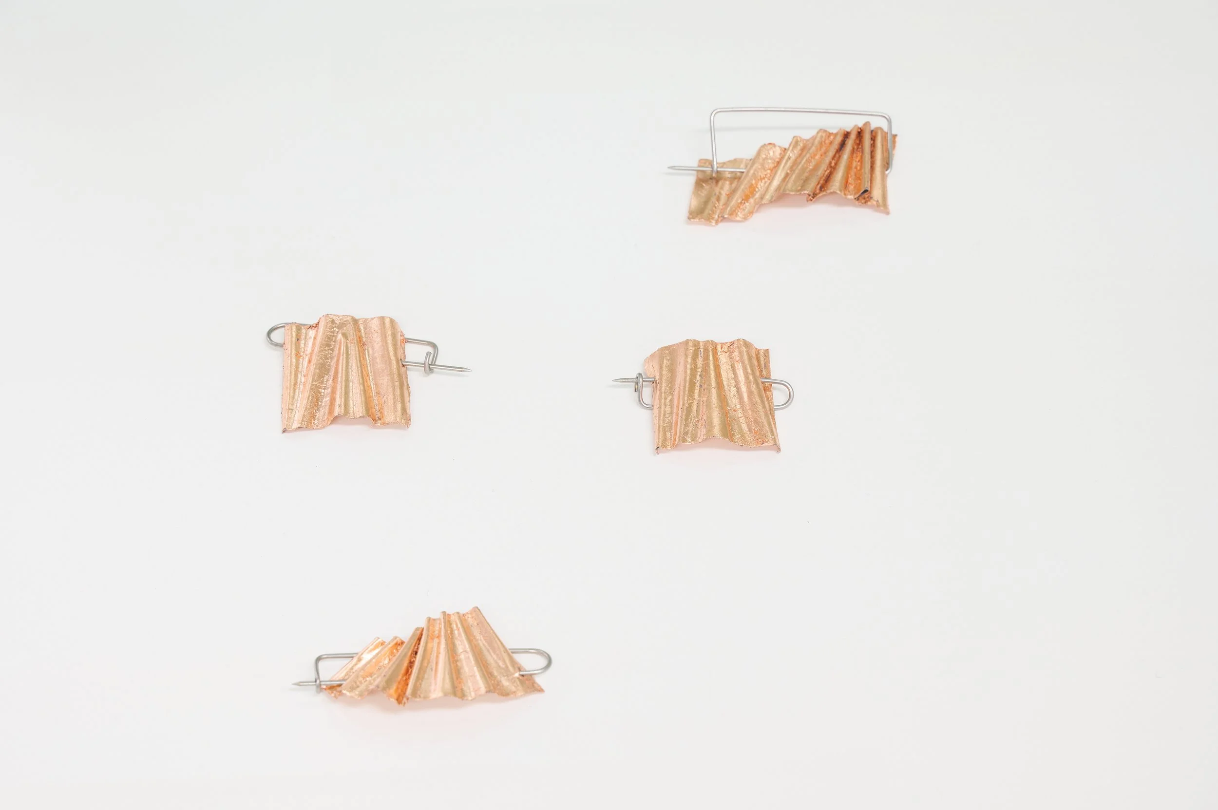 Tom Burless, 'Kekkai Shroud - Brooch #1 - #4', aluminium, stainless steel, copper leaf, 10 x 7 x 2.5 (approx.) each, installation view, Alta Forma, Naarm/Melbourne, 2026. Photograph: Ross Coulter