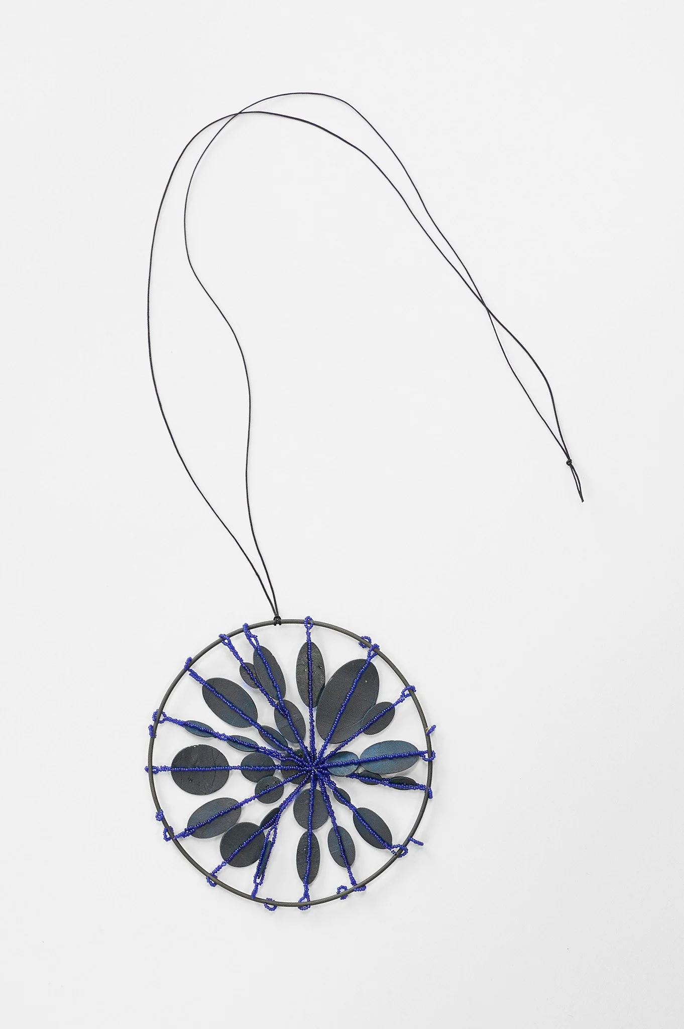 26. Mascha moje, ‘Untitled’, (blue circle), 2025, oxidized mild steel circle, porcelain and cobalt glass beads, pendant 9.5cm diameter, cord 35cm. Price: $1,400 