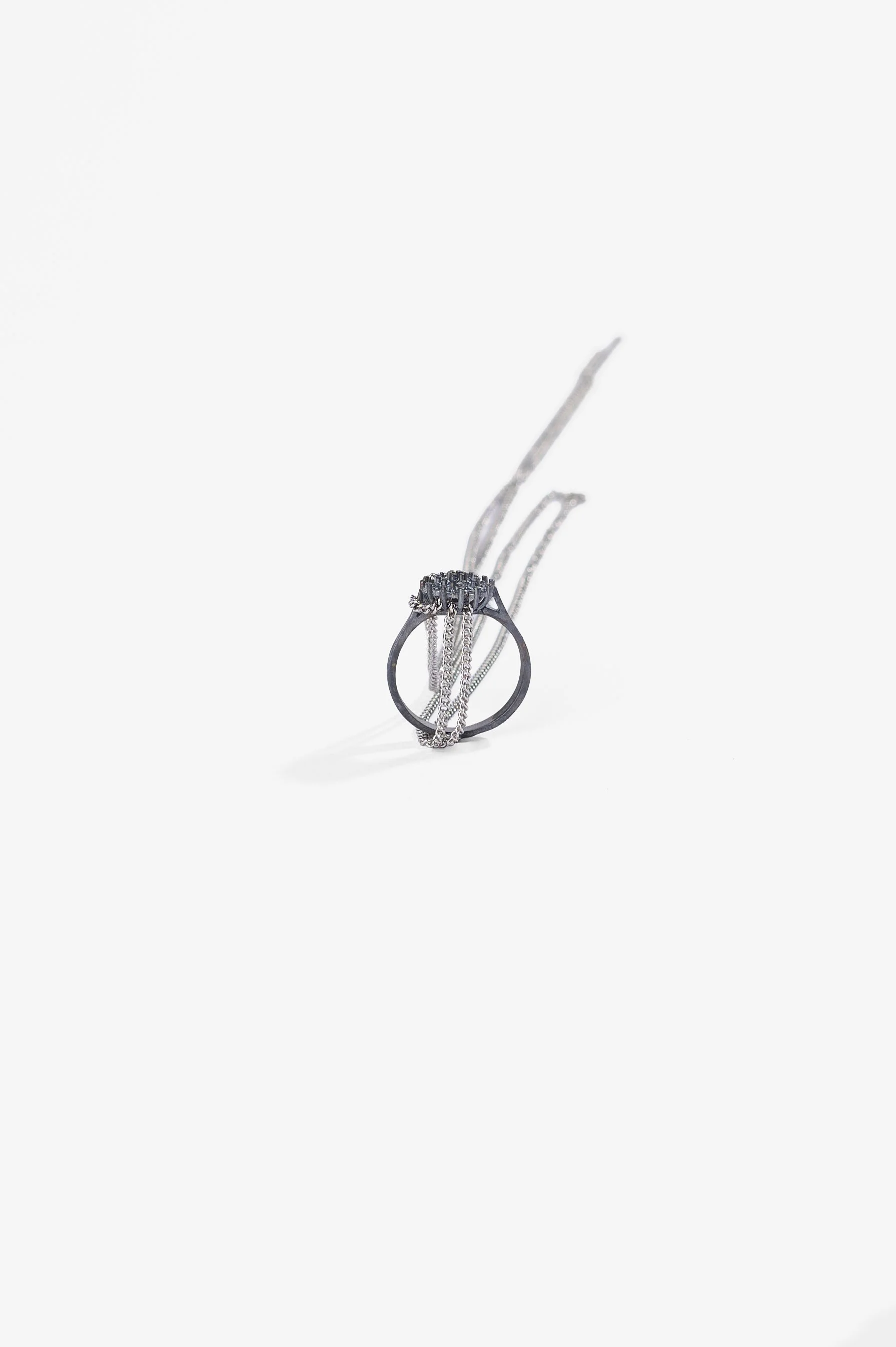 Debris Facility, Capsule Collapsing, oxidised silver, surgical stainless steel, aluminium, 3D printed nylon, anodised stainless steel, printed acetate, mirror frame, acrylic display, acrylic paint, iridescent pigment, 2026. Metal rings $365 each. Pho